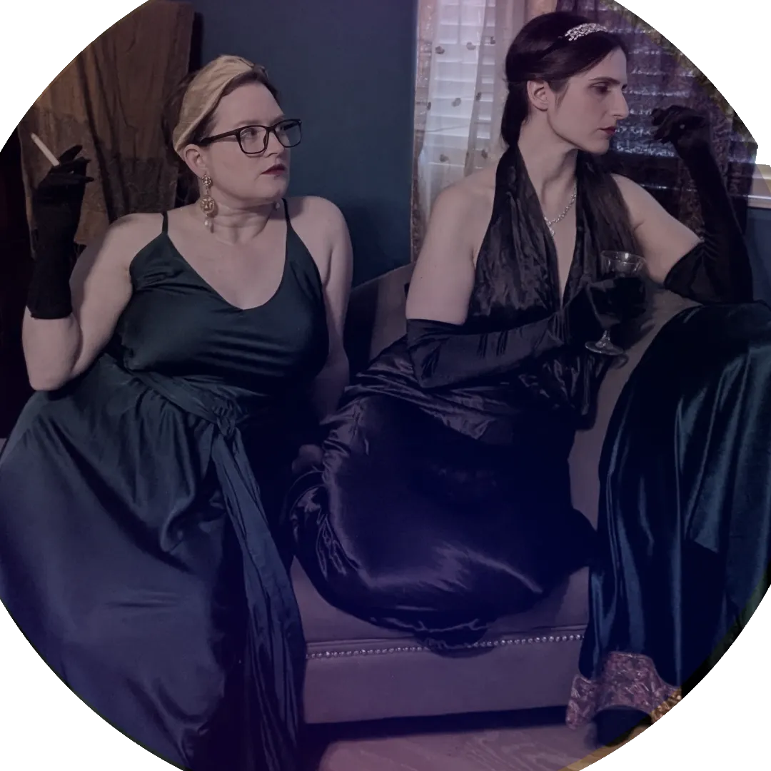Two women in 1930s attire sitting on a couch